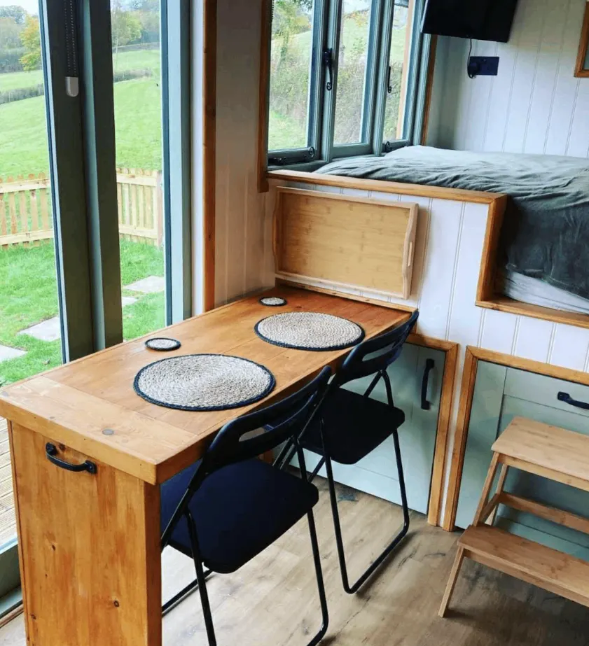 Custom timber dining area and fitted furniture in a glamping pod interior