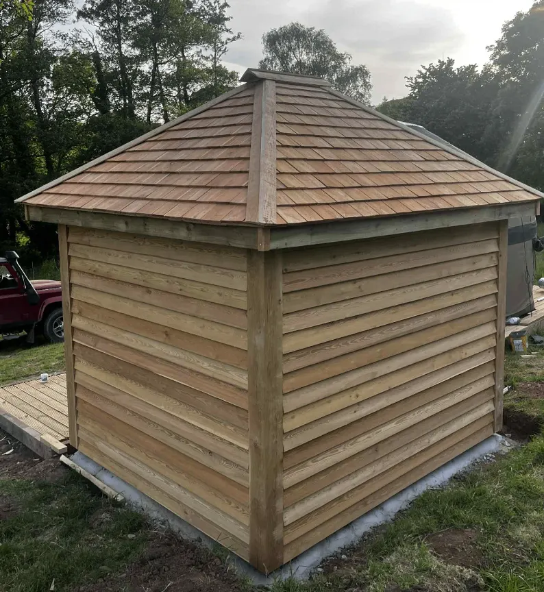 Timber-clad garden building with a shingle roof