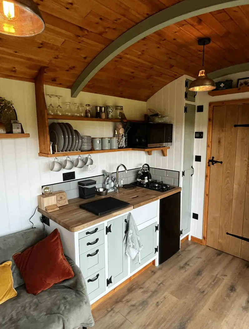 Compact fitted kitchen inside a glamping pod